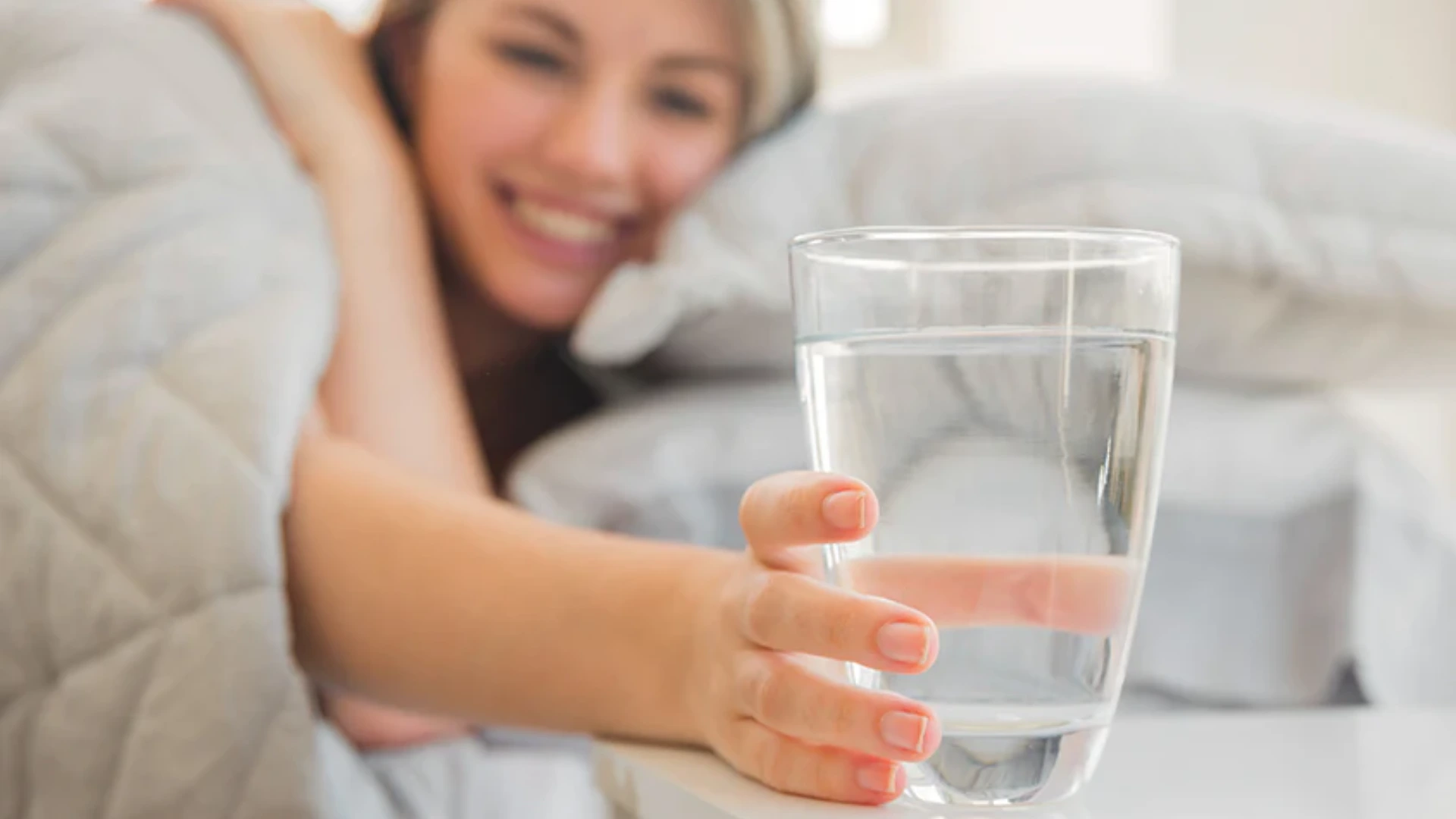 Drinking water when wake up Woman drinking water when she is awaking, for keeping hydrated during summer
